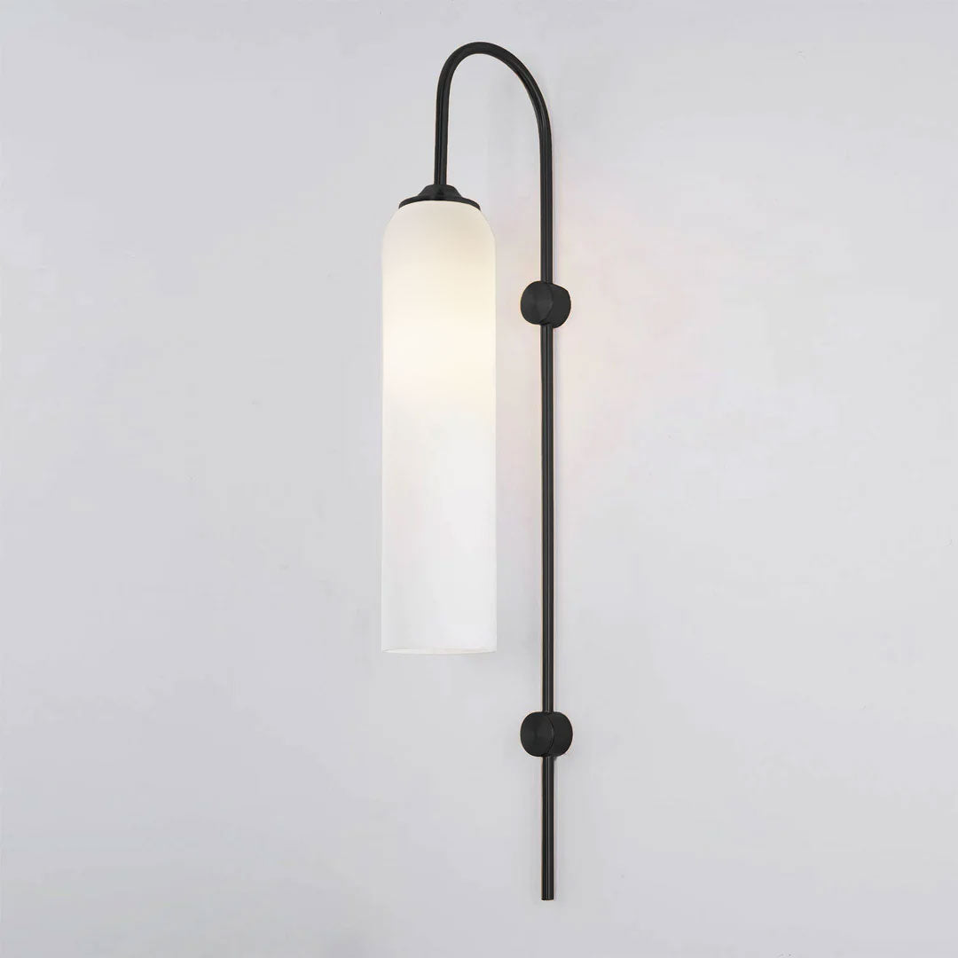 Modern glass wall lamp shown lit with a warm cylinder glow