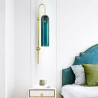 Modern glass wall lamp with arched brass arm and glass cylinder shade
