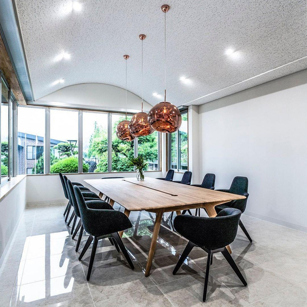 Molten pendant light shade glowing warmly above a table