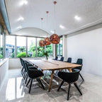 Molten pendant light shade glowing warmly above a table