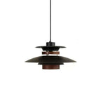 A black Clérachic pendant on a long black cord, shown on a plain white backdrop.