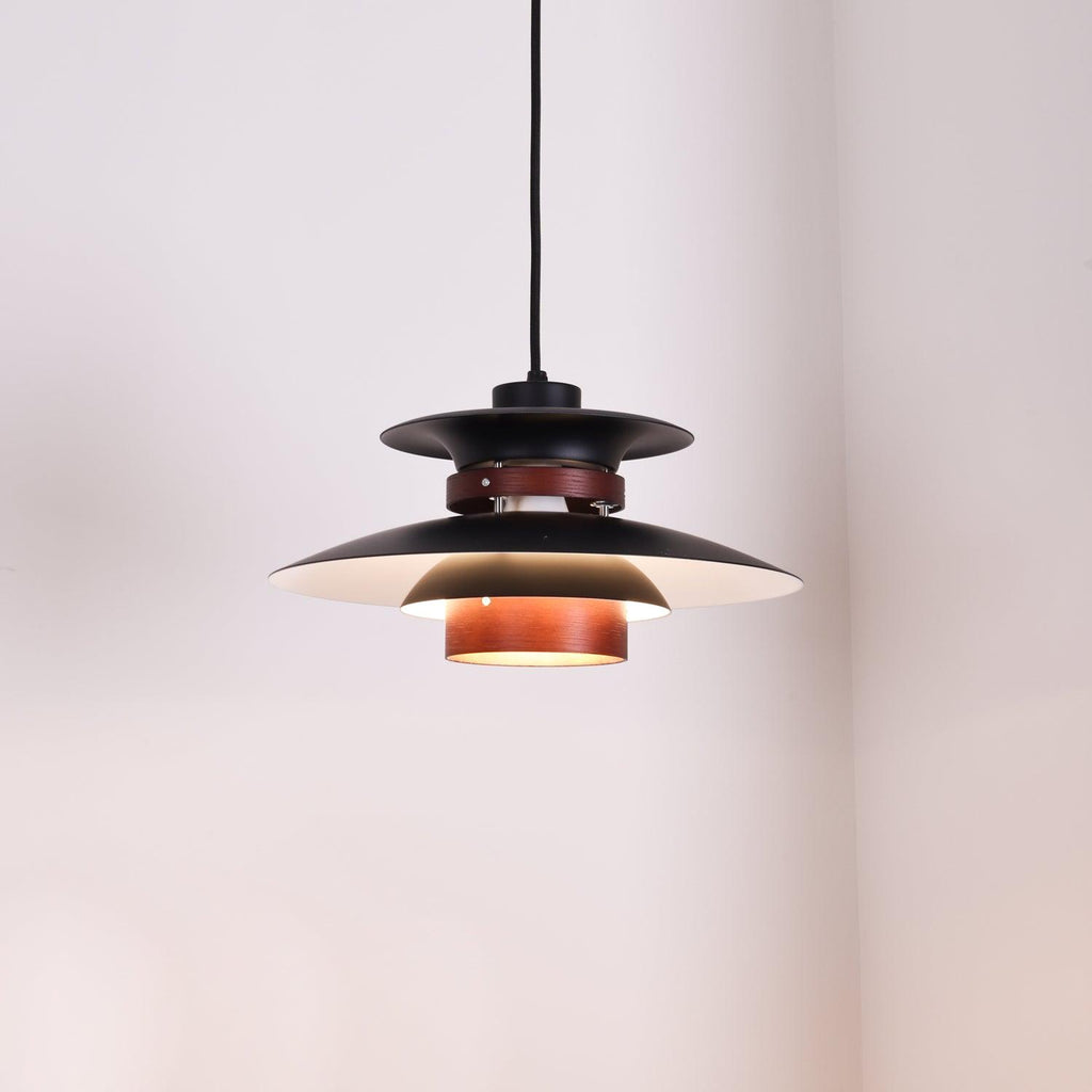 Close view of the lit black shades and walnut ring on this Clérachic pendant.