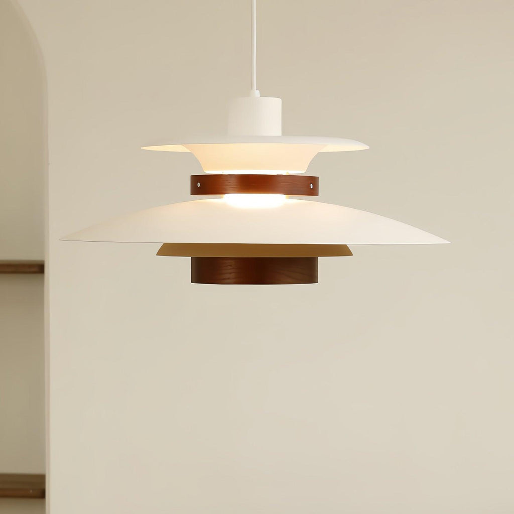 A lit white Clérachic pendant hangs near a plain wall and doorway edge.