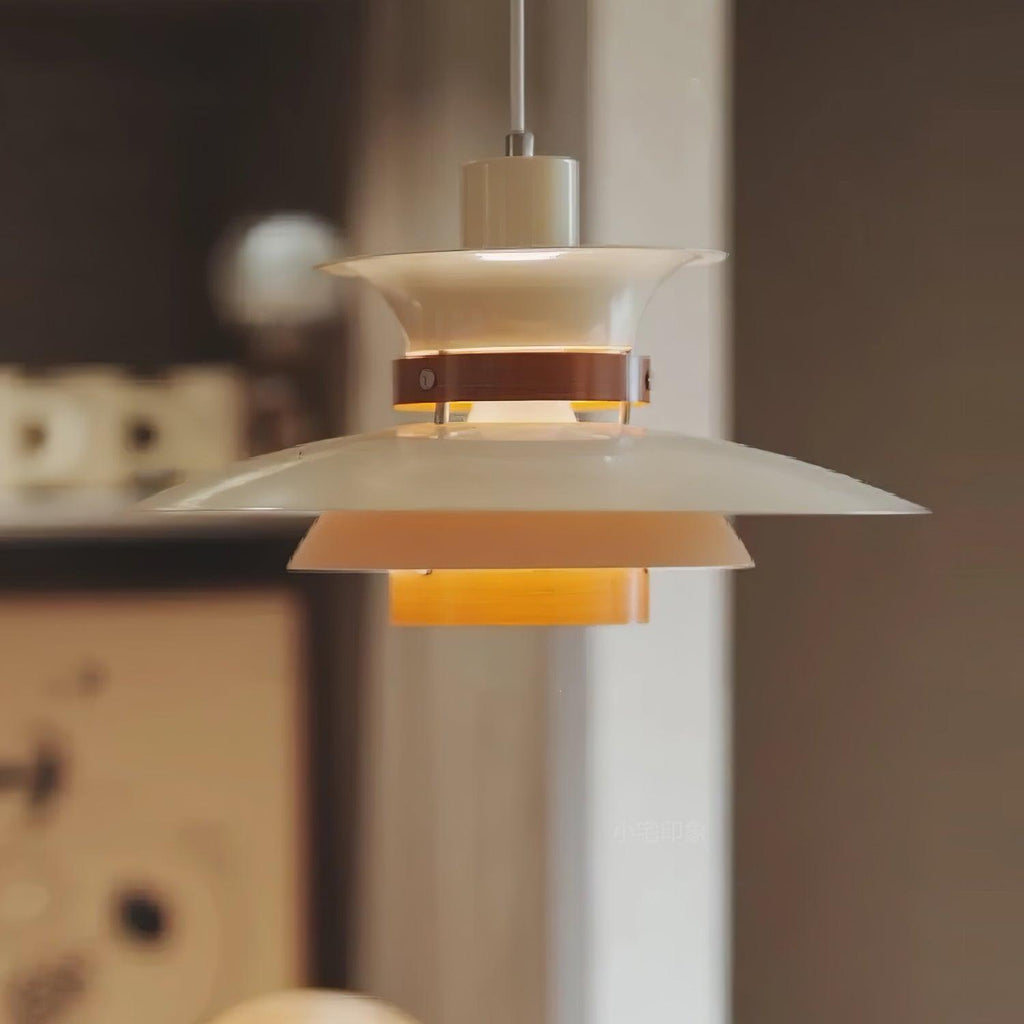 Close view of the lit white shades on this Clérachic pendant against a dark backdrop.