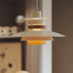 Close view of the lit white shades on this Clérachic pendant against a dark backdrop.