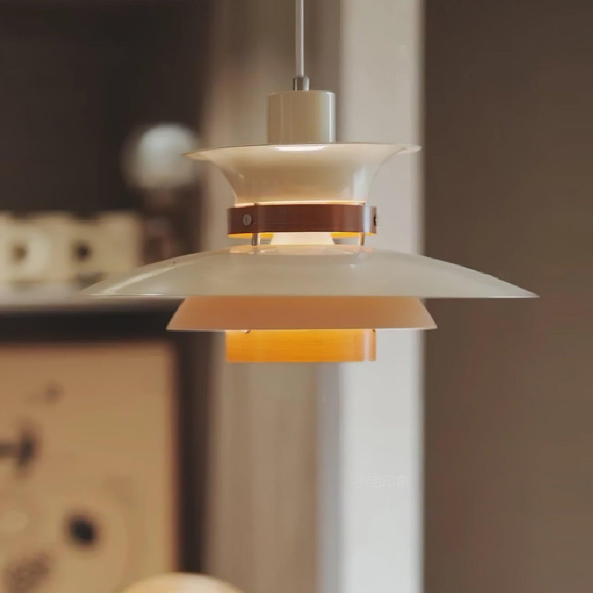 Close view of the lit white shades on this Clérachic pendant against a dark backdrop.