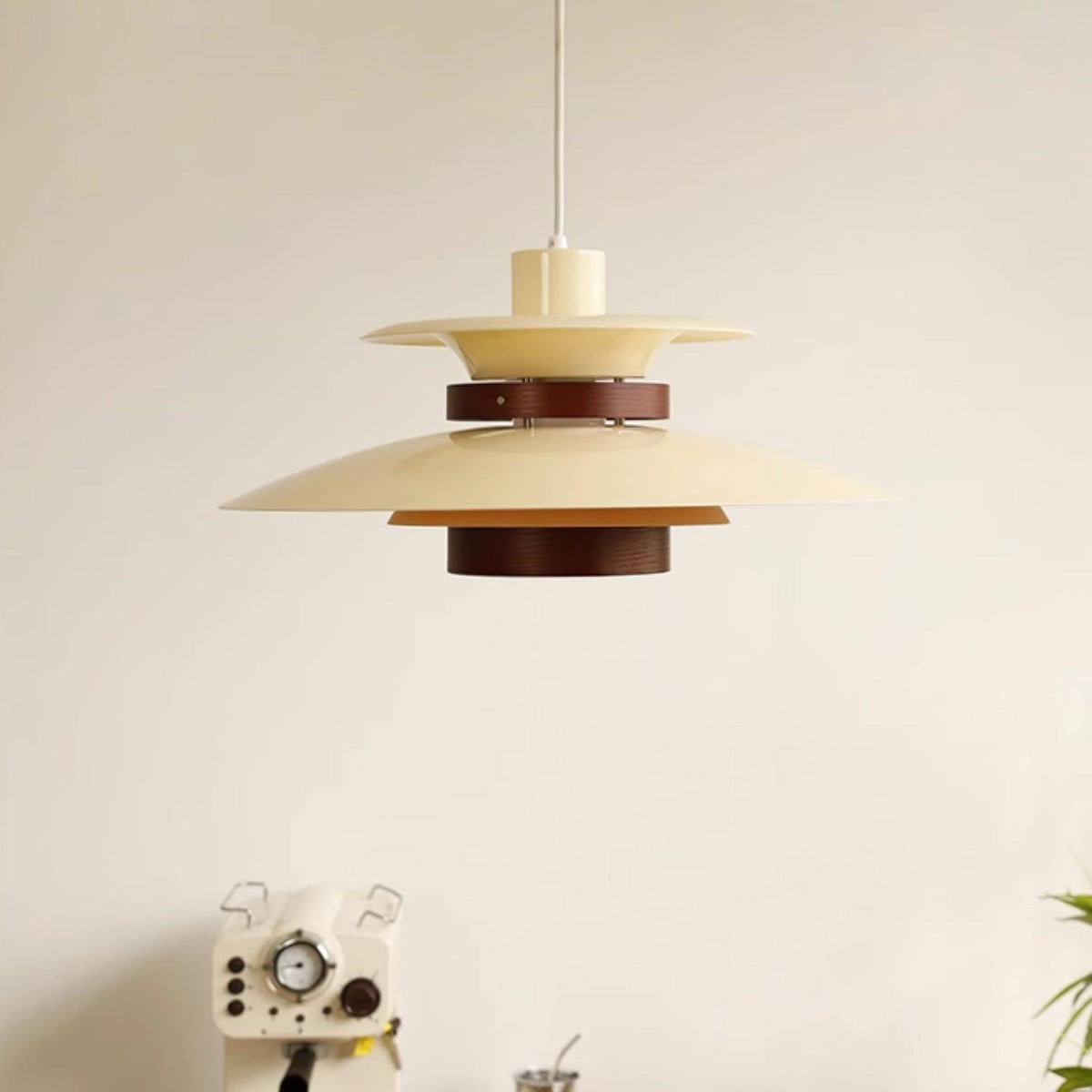 Wide view of a beige Clérachic pendant hanging above a side table with a radio prop.