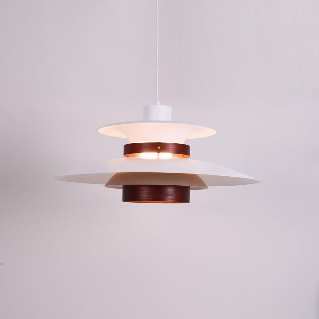 Close view of the lit white shades and walnut ring on this Clérachic pendant.