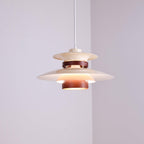 A lit beige Clérachic pendant hangs low in a plain lavender-grey corner room.
