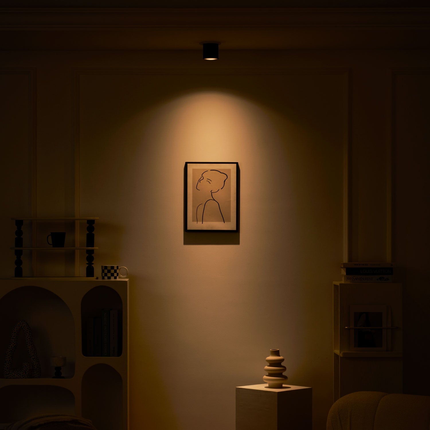 Modupoint ceiling light shown lit in a warm white tone in a styled interior