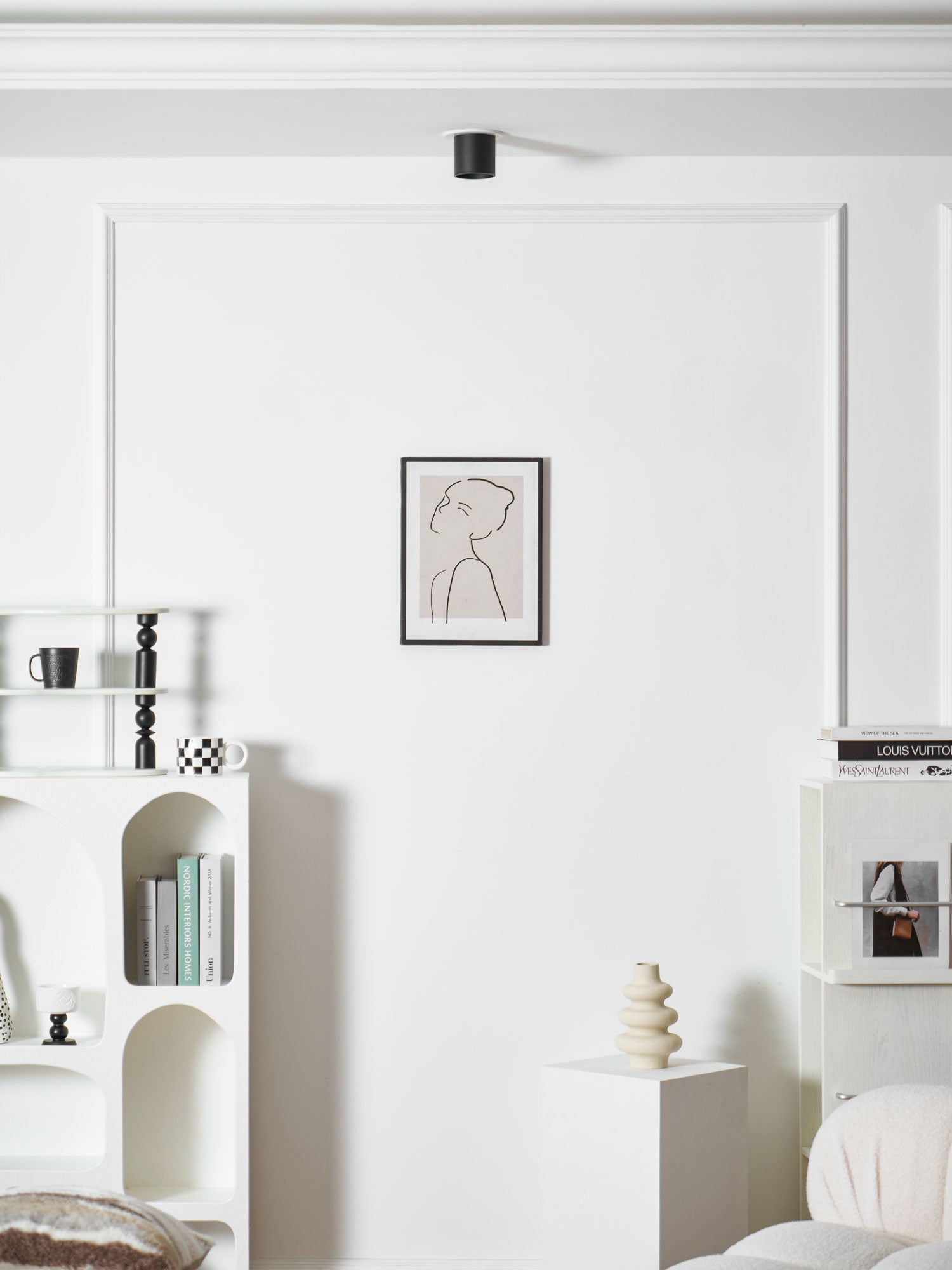 Modupoint ceiling light shown lit in a warm white tone in a styled interior
