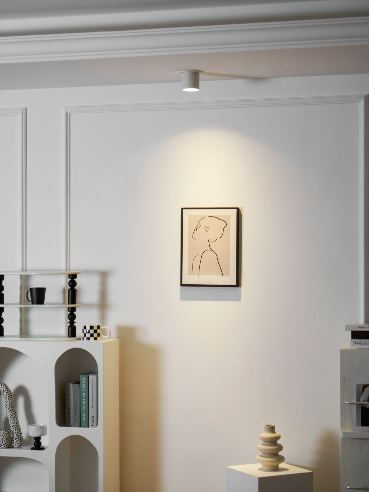 Modupoint ceiling light shown lit in a warm white tone in a styled interior