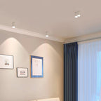 Modupoint ceiling light shown lit in a warm white tone in a styled interior