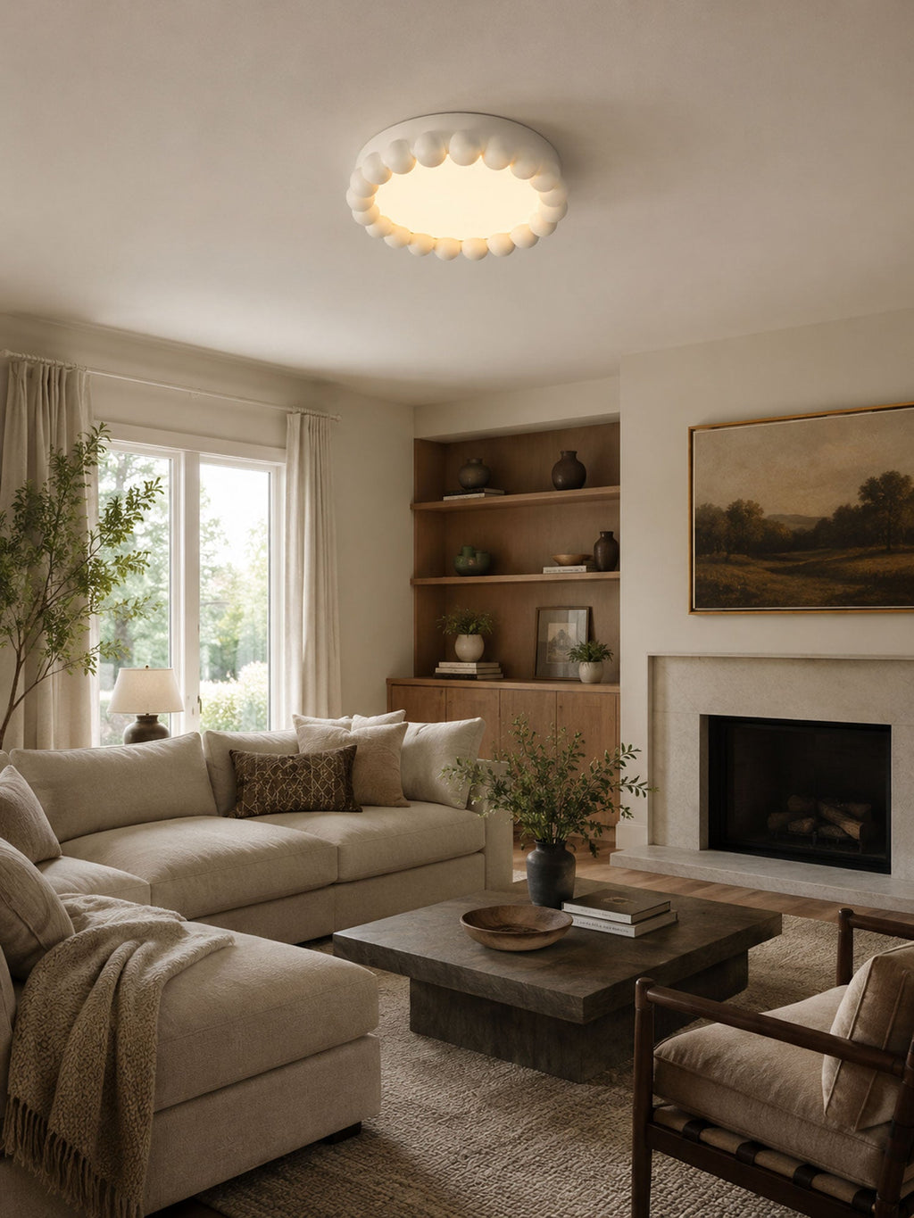 This Clérachic ceiling light in white lights a living room with a fireplace, built-in shelving and a neutral sectional sofa.