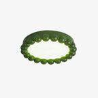 Close view of this Clérachic ceiling light in green, its beaded resin ring shown unlit on white.