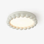 Close view of this Clérachic ceiling light in white, its beaded resin ring framing a glowing acrylic diffuser.