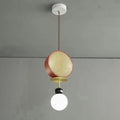 Small single-arm Clérachic pendant with a copper cane drum and opal glass globe, hanging against a plain grey wall.
