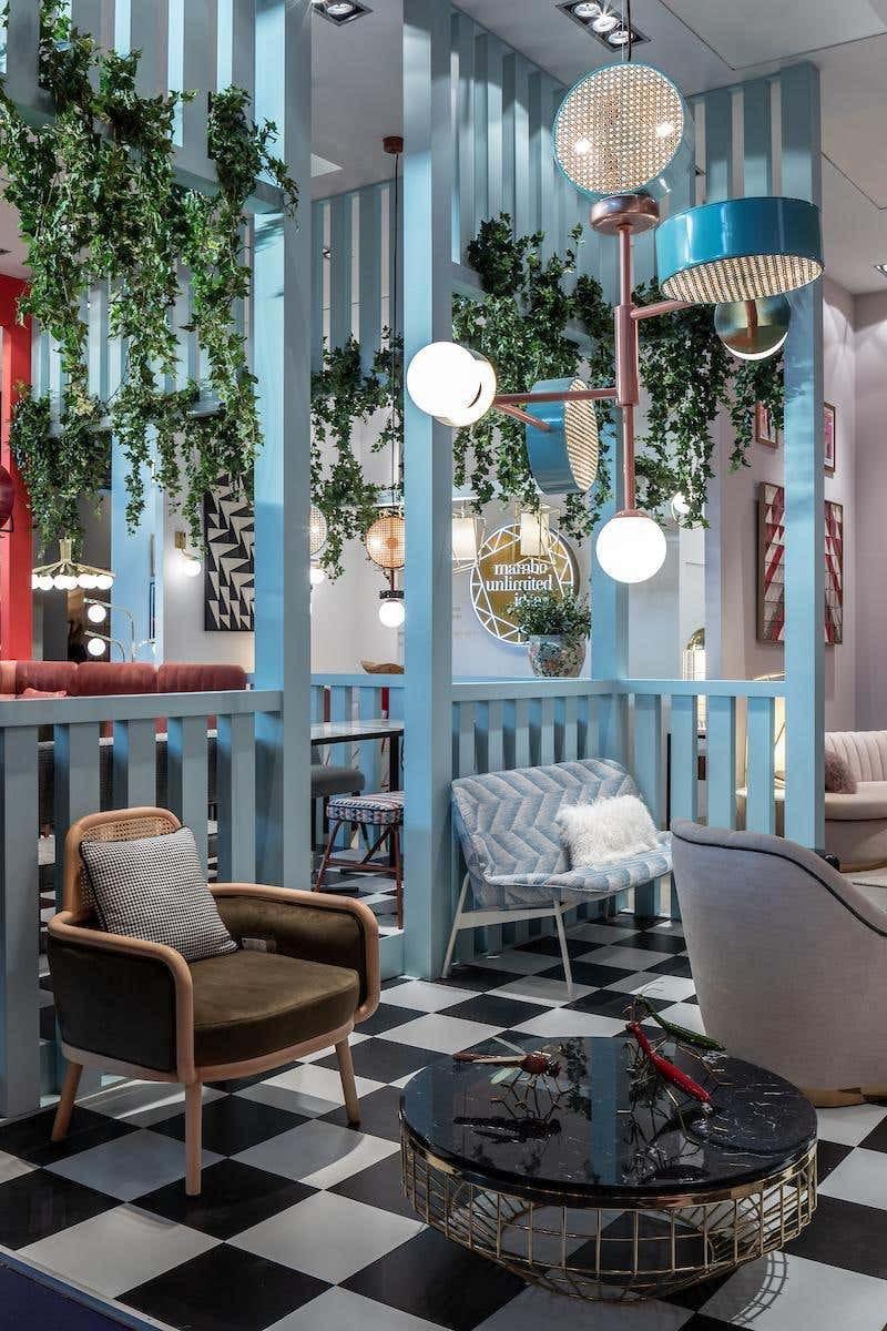 Clérachic pendant with copper and teal arms hanging among trailing houseplants above a black-and-white checkerboard floor.