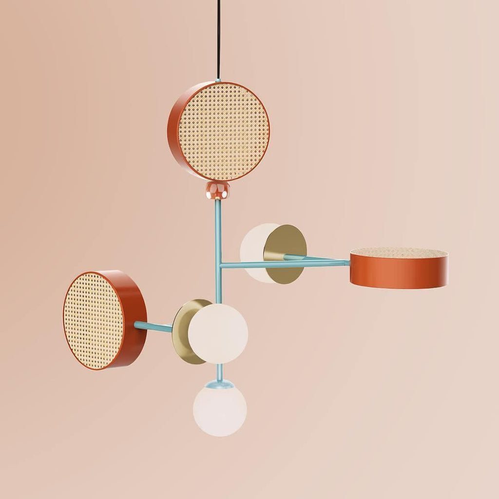Five-arm Clérachic chandelier in coral, teal and cream tones, photographed against a dusty pink studio backdrop.