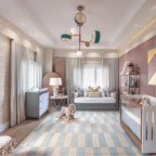 Large Clérachic chandelier centred above a crib and daybed in a patterned nursery, its coloured drums and globes catching the light.