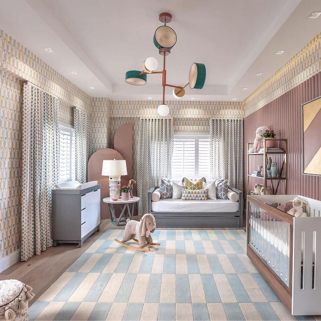 Large Clérachic chandelier centred above a crib and daybed in a patterned nursery, its coloured drums and globes catching the light.