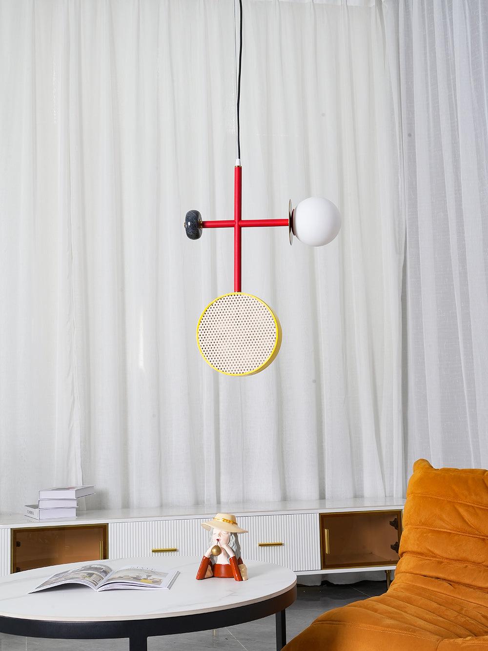 A third crop of the Clérachic pendant above the round table, sheer curtain and orange chair, taken from a slightly lower angle.