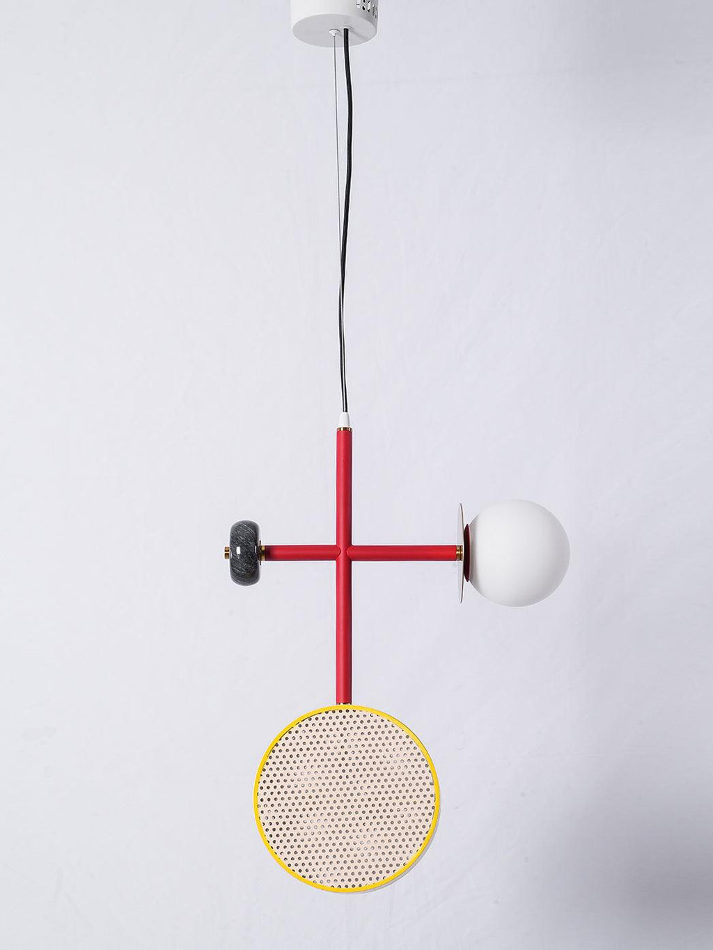 Two-armed Clérachic pendant with a red rod, dark bead joint, yellow-rimmed cane drum and opal glass globe, on white with a ceiling plate visible.