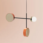 Two-armed Clérachic pendant with a copper cane drum and opal globe on a black cross-rod, plus a second drum shade hanging lower on its own cord.