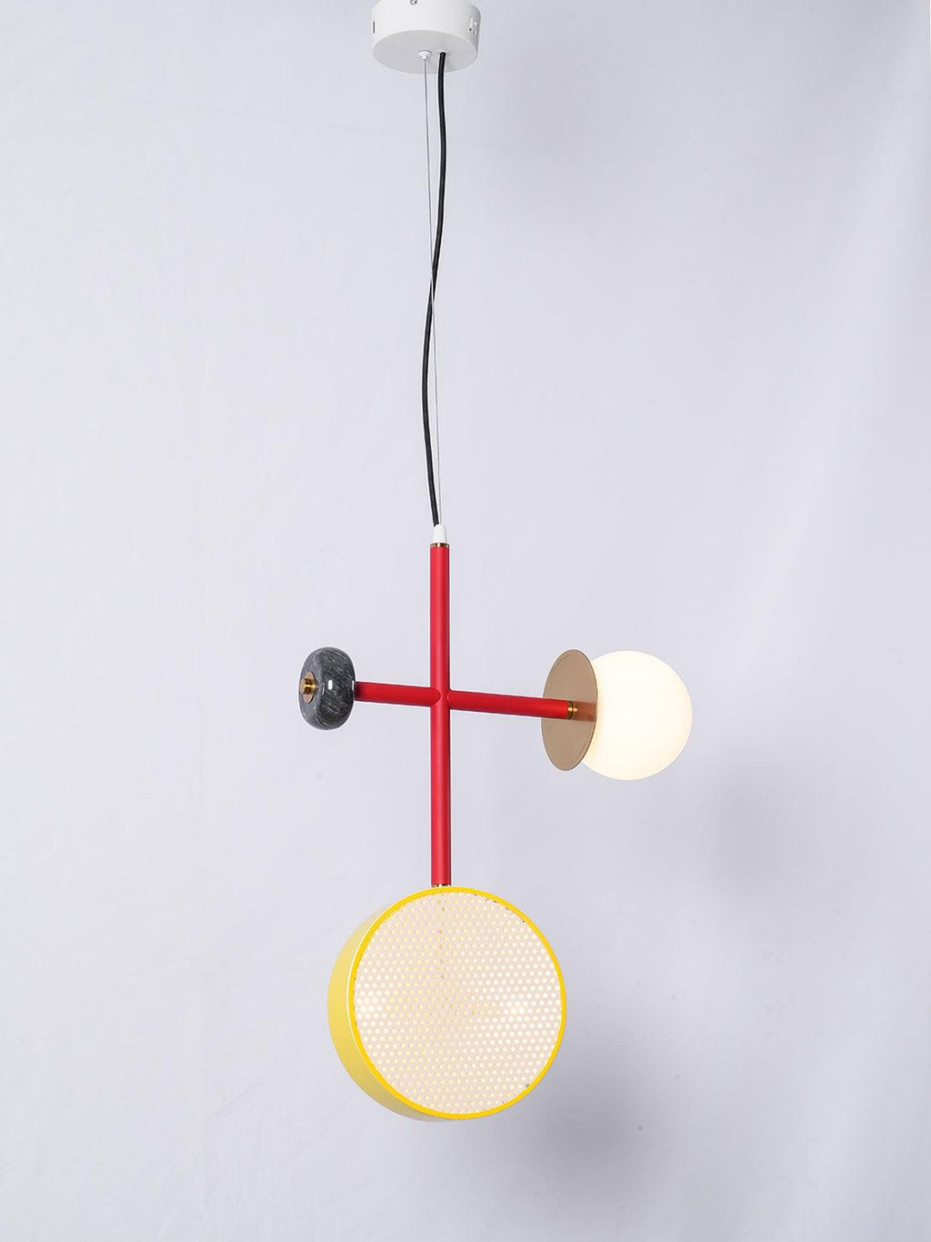 Clérachic pendant with a red cross-rod, dark bead end cap, yellow-rimmed cane drum and opal glass globe, hung from a white ceiling plate.