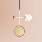 Clérachic pendant on a pale cream rod with a small copper accent disc, its cane drum and glass globe suspended against a plain blush backdrop.