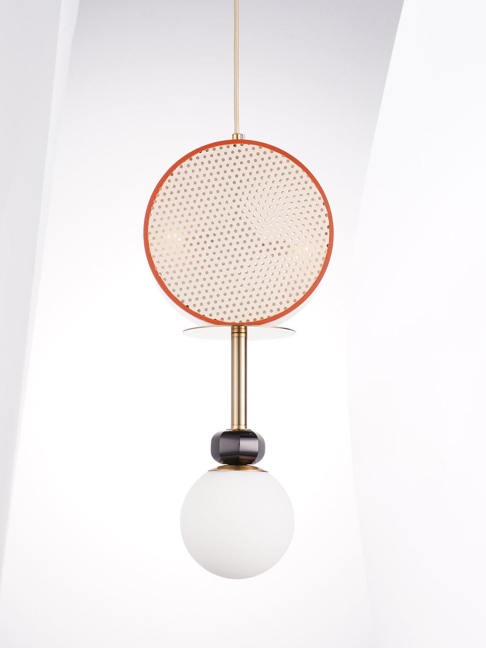 Clérachic single-drum pendant with a terracotta rim, brass stem and opal glass globe, hanging against a white angled wall.