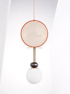 Clérachic single-drum pendant with a terracotta rim, brass stem and opal glass globe, hanging against a white angled wall.