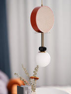 A closer crop of the same Clérachic pendant against the teal curtain, its cane drum shade filling more of the frame.