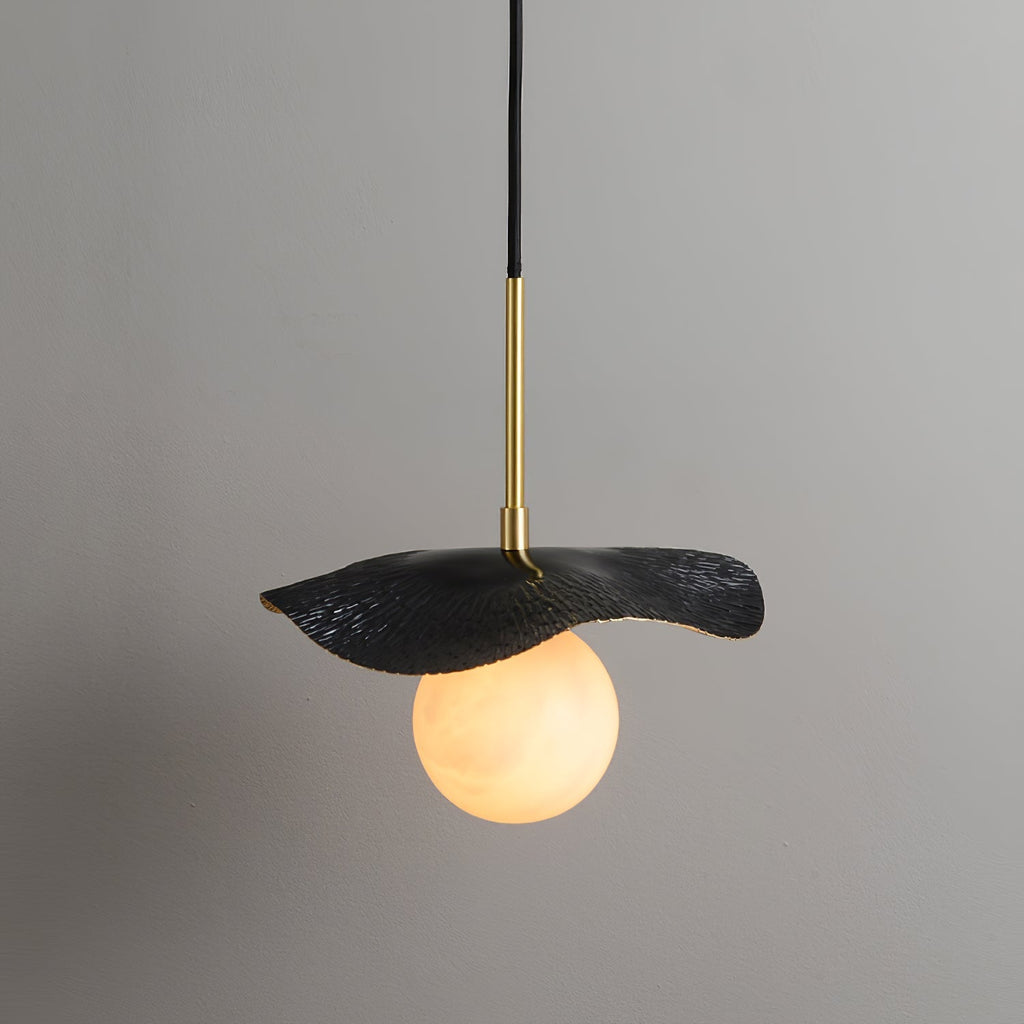 The black-finish version of the pendant, its matte leaf shade lit from below by the alabaster globe