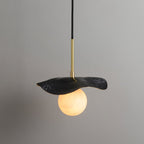 The black-finish version of the pendant, its matte leaf shade lit from below by the alabaster globe