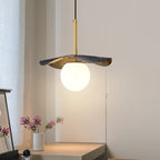 The pendant lit in a bedroom corner above a dressing table with pink blossoms and a sheer curtain