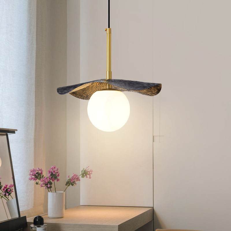 The pendant lit in a bedroom corner above a dressing table with pink blossoms and a sheer curtain