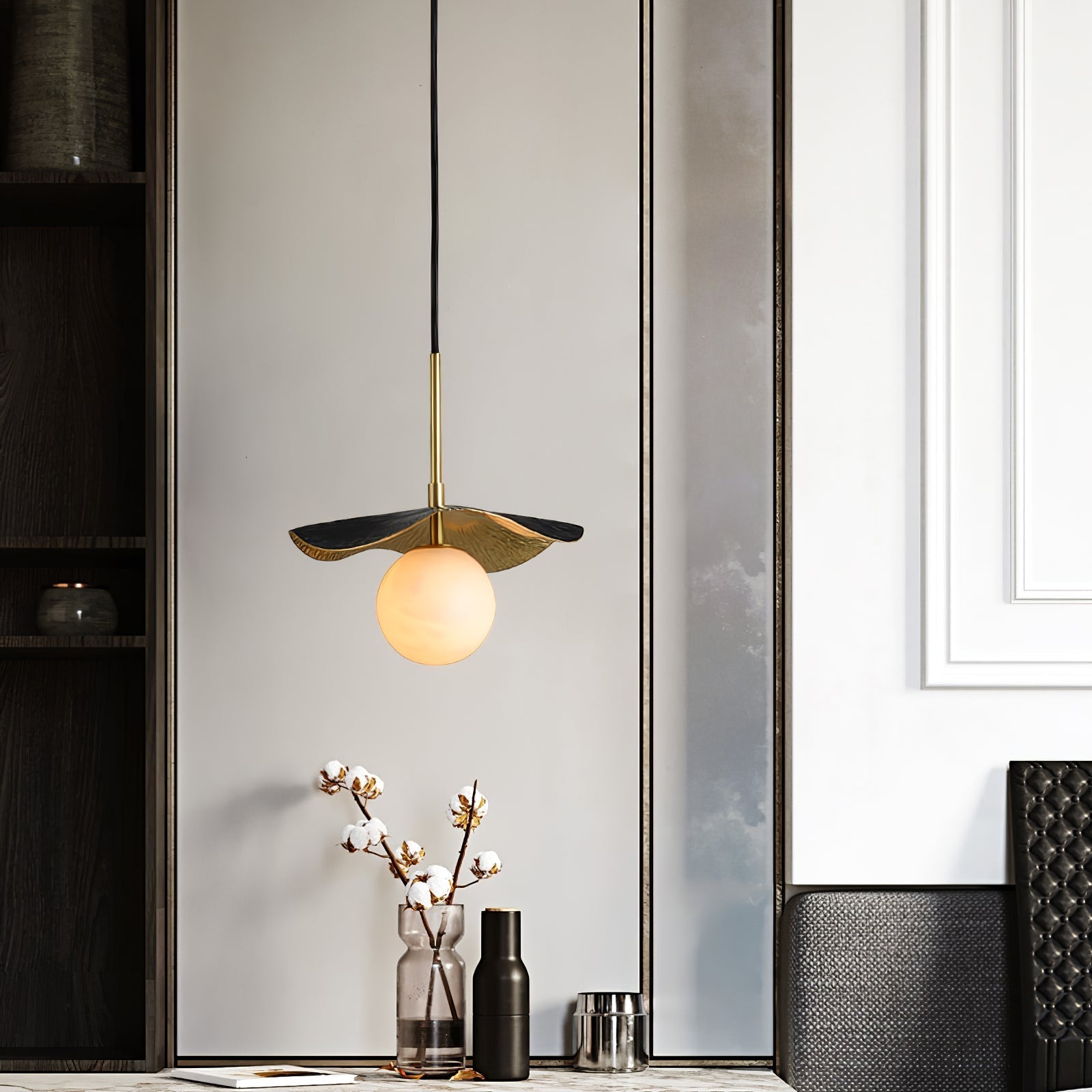Wider view of the pendant lit above a console table, with dark joinery and a panelled wall behind
