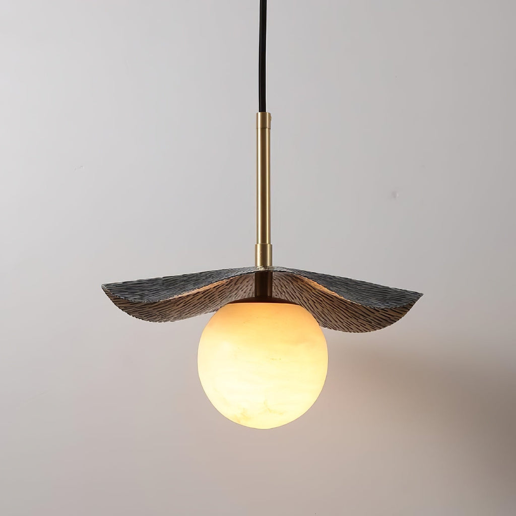 Low angle on the pendant showing the ridged underside of the brass shade and the amber-lit globe