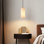 Hecate pendant lighting a dark bedside table against textured plaster, warm pool of light on the wall.