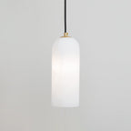Zashayra pendant on a pale grey wall, lit softly so the light gathers in the middle of the shade.