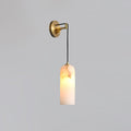 Brass backplate and slim arm of the Vaelara alabaster wall sconce holding the lit stone shade