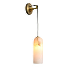 Full view of the Vaelara alabaster wall sconce in brass, lit, on a plain white background