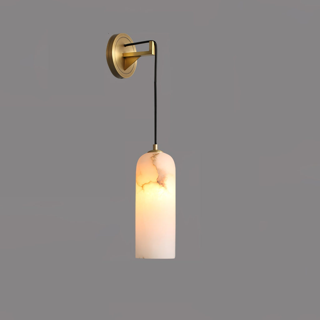 Vaelara alabaster sconce against a darker grey wall, warm light glowing through the veined stone