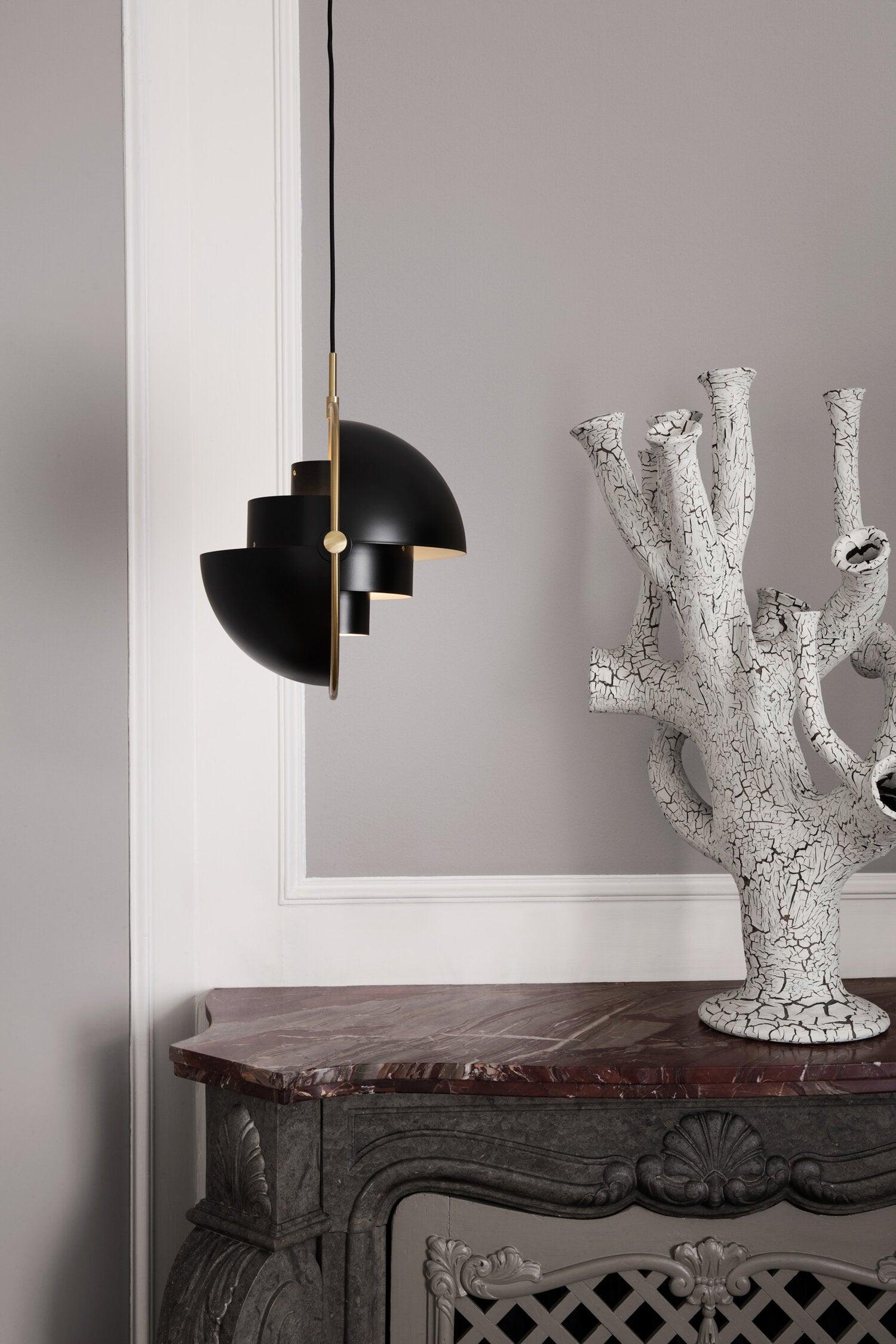 Multi-Lite pendant light with two movable hemisphere halves hanging in a styled interior