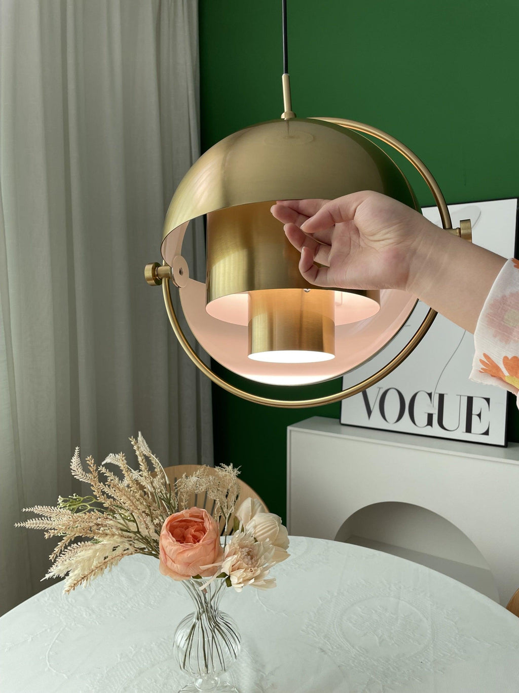 Multi-Lite pendant light with two movable hemisphere halves hanging in a styled interior