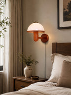 Mushroom-shaped oak wood wall lamp casting warm ambient light in a bedroom
