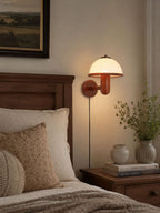 Oak wood mushroom wall lamp mounted beside a bed for soft reading light