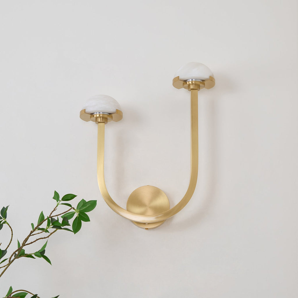 Vitalira Double Alabaster Wall Light in brushed brass on a white wall, domes unlit and chalky white.
