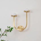 Vitalira Double Alabaster Wall Light in brushed brass on a white wall, domes unlit and chalky white.